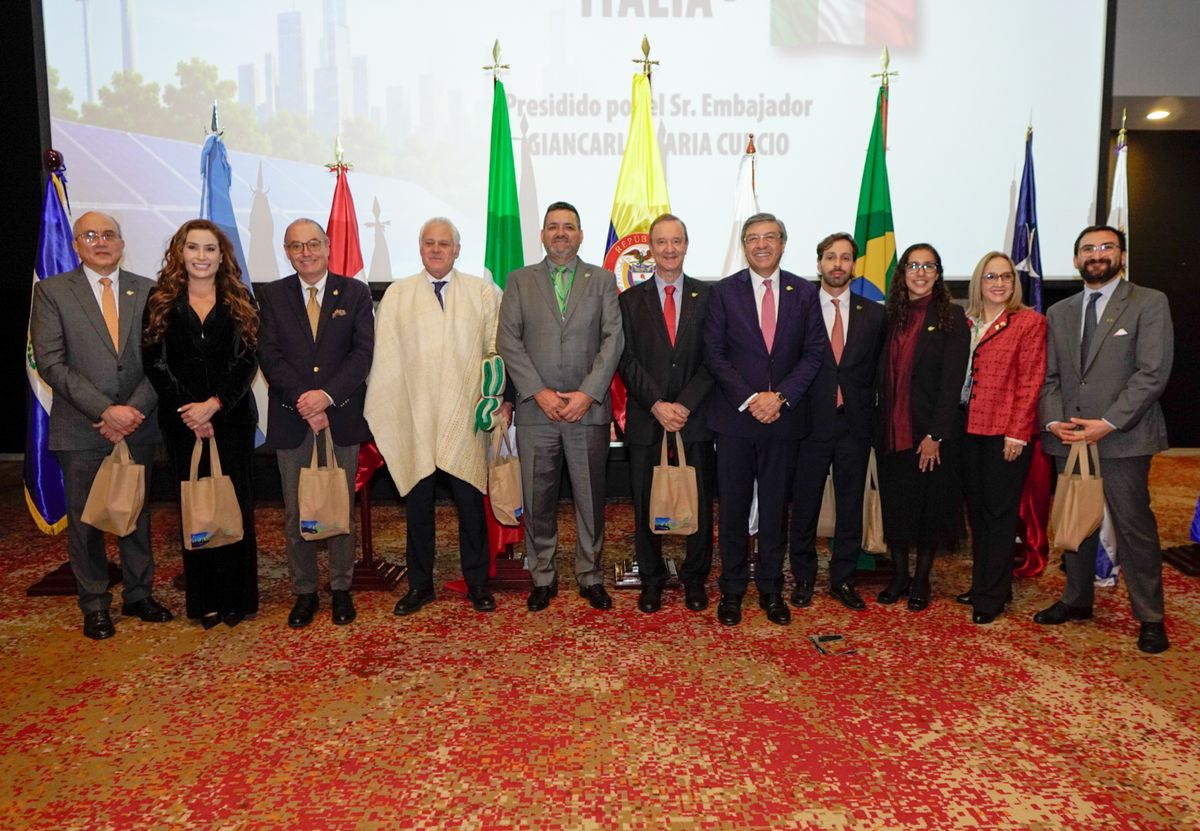 Foto de grupo de asistentes frente a banderas de varios países en el congreso